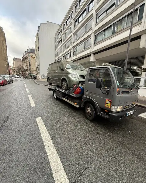 Utilitaire chargé sur un plateau dans une rue parisienne